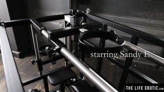 Kinky blonde Sandy E fingers her muff in a BDSM cage